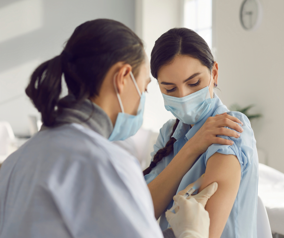 a man administering vaccination on a woman in a clinic